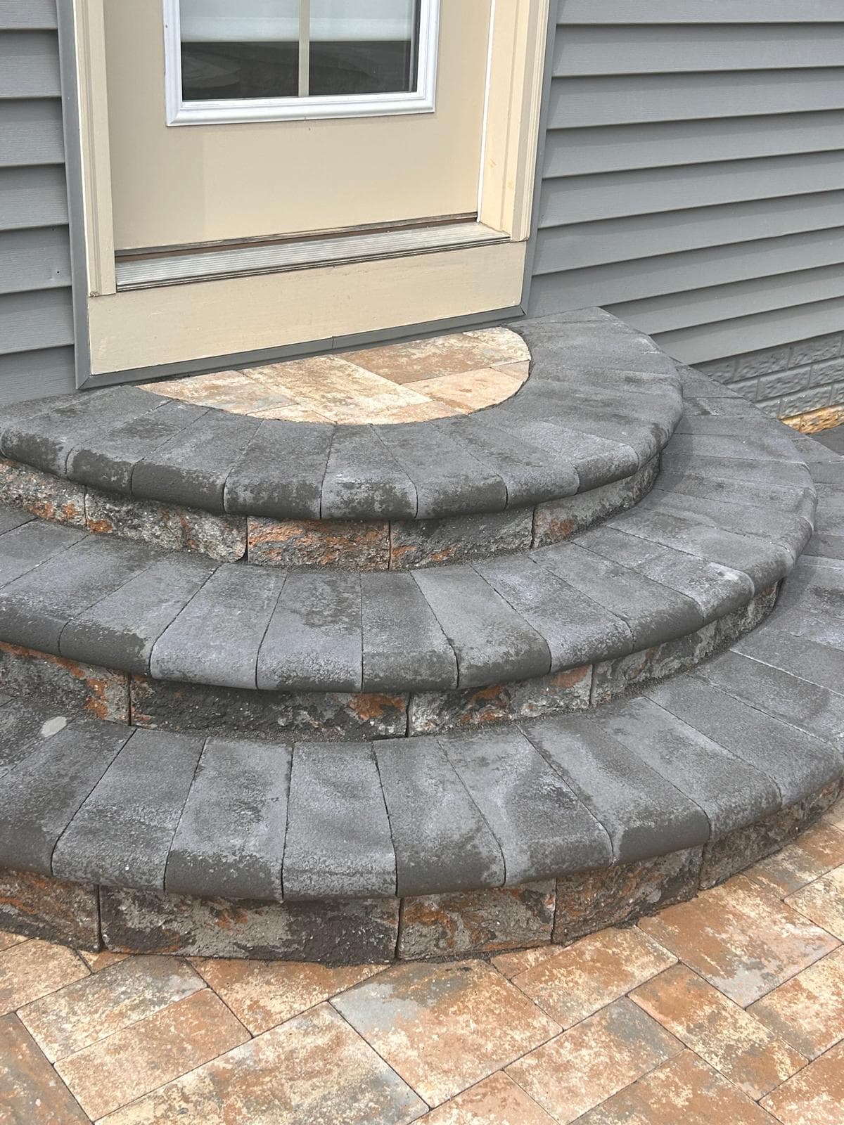 Bluestone semicircular steps and paver patio by Kaeler