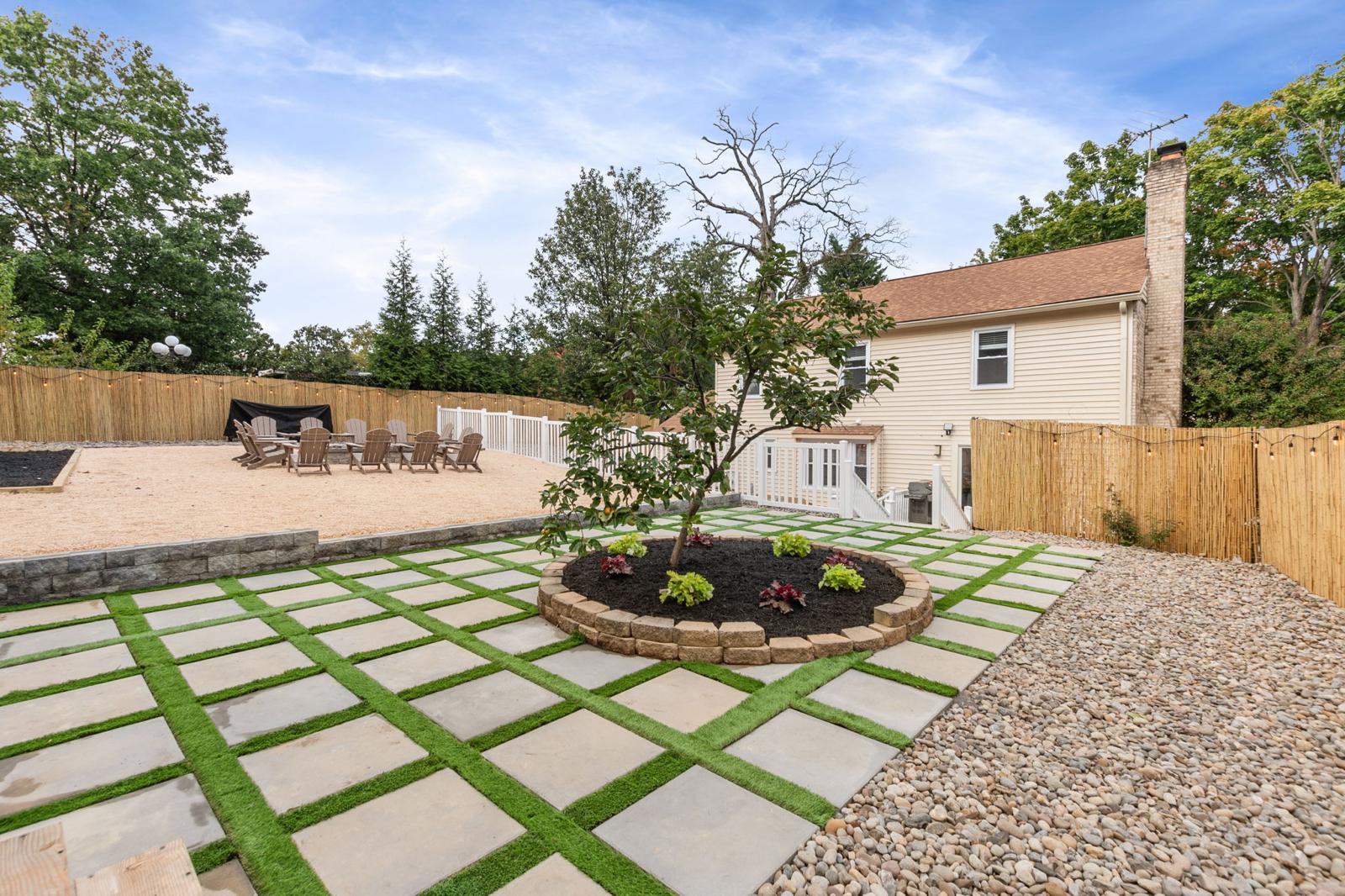 Fresh paver-and-turf grid with a new circular planting bed by Kaeler