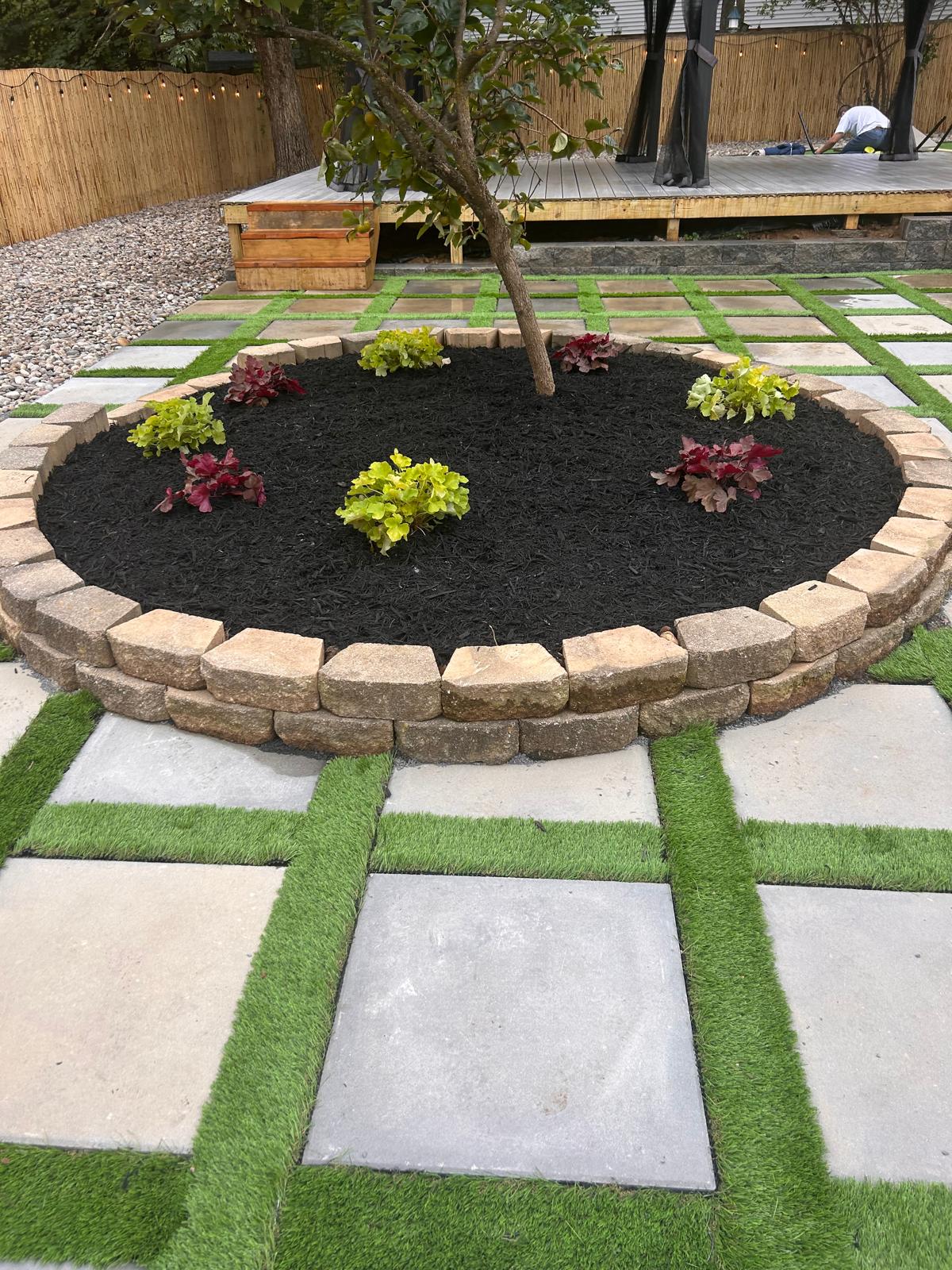 Stone-edged tree ring with new perennials and mulch by Kaeler